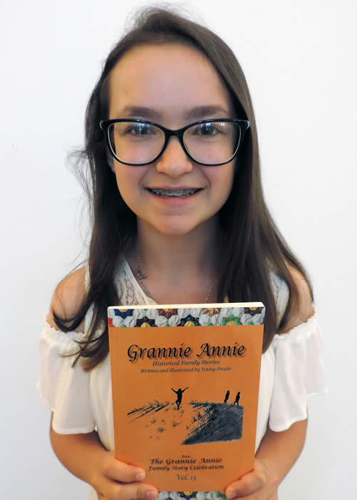 Grannie Annie published student 2018, holding a copy of "Grannie Annie, Vol. 13" 