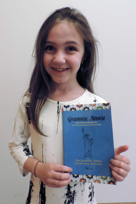 Grannie Annie published student 2019, holding a copy of "Grannie Annie, Vol. 14"